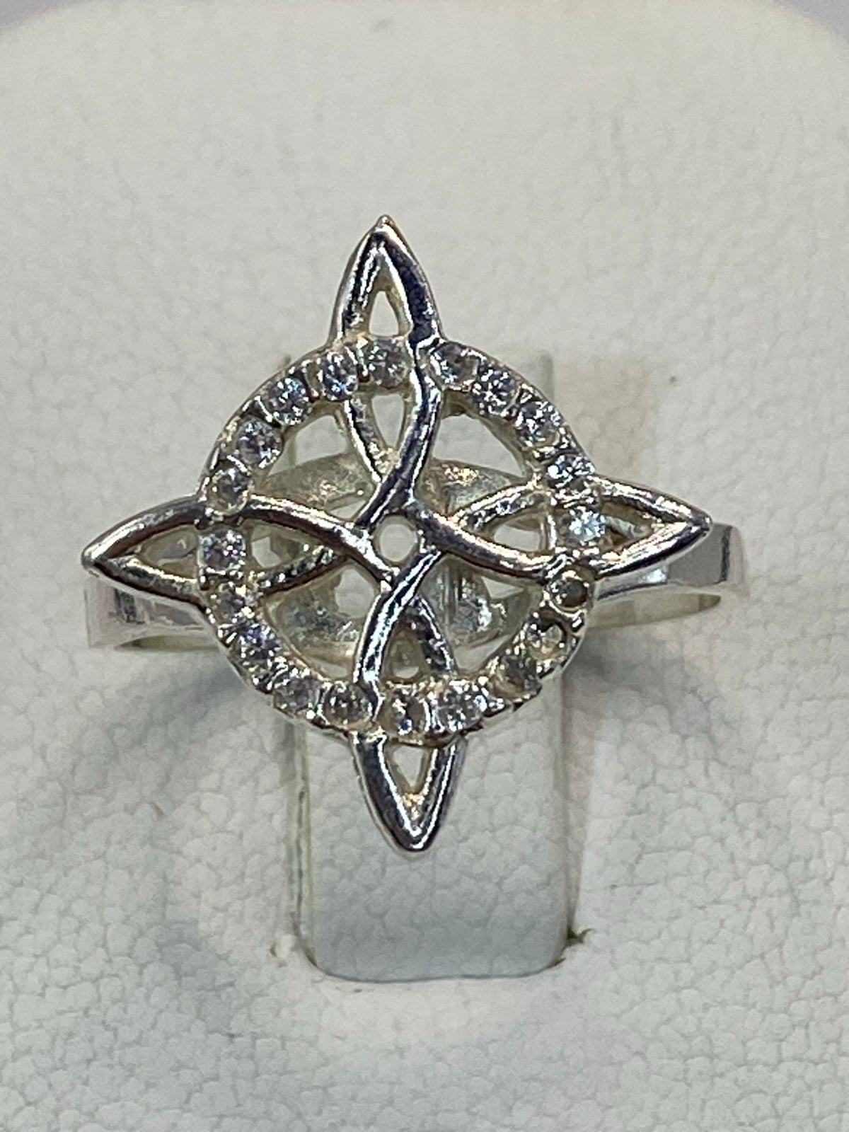 Anillo puesto en dedo, mostrando la delicadeza del calado a la luz
