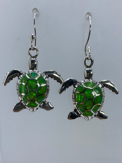Arete de tortuga de plata 950 mostrando detalle del caparazón y piedra verde