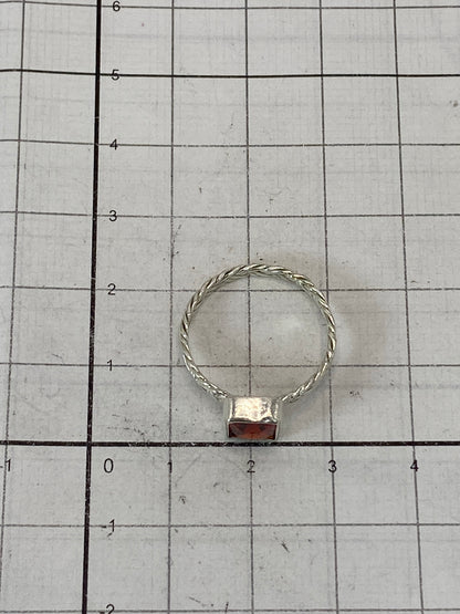 Anillo sobre fondo blanco mostrando el Quinto 925 y la piedra roja