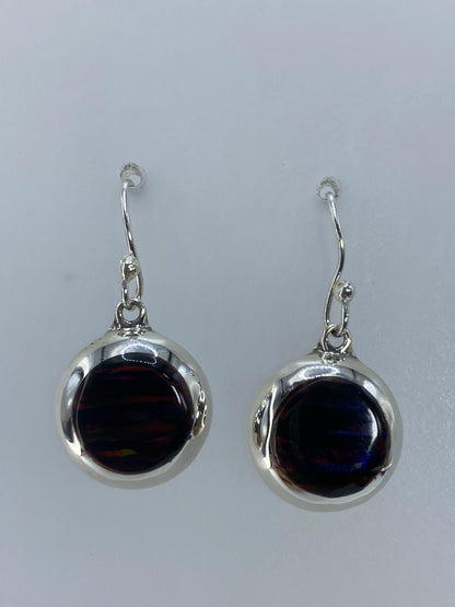 Arete individual de plata con ópalo de fuego multicolor en la mano
