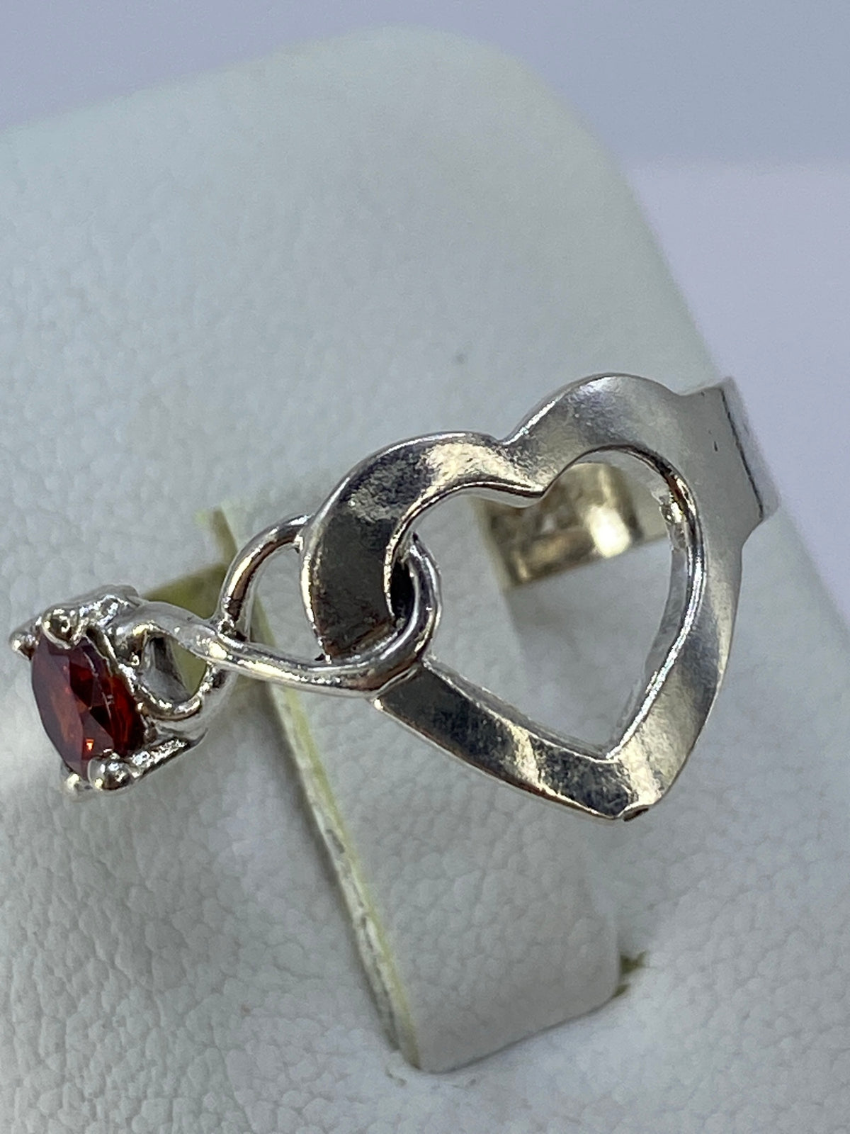 Detalle del corazón perforado y la circonia roja engastada