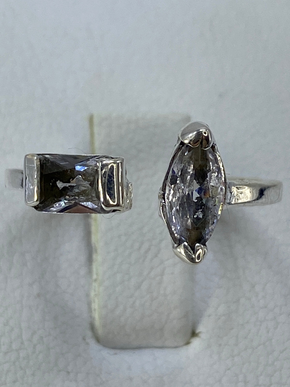 Anillo de plata solitario con circonia facetada en la mano de una mujer