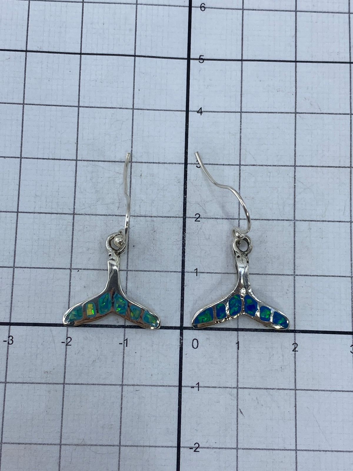 Aretes de ópalo en la mano, mostrando tamaño y peso (3 cm de largo)