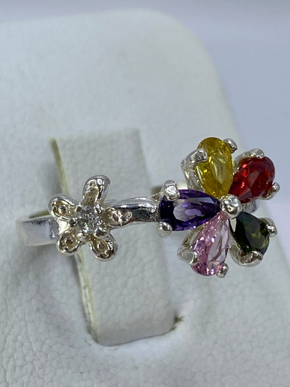 Detalle del engaste a mano de las circonias multicolores en el anillo de plata 925