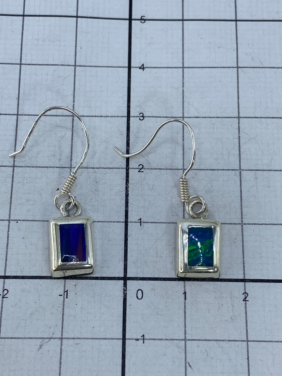 Aretes de plata con ópalo multicolor visto desde atrás mostrando los ganchos