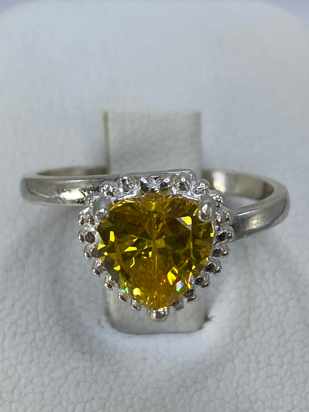 Anillo solitario de plata 925 con circonia amarillo engastado, vista frontal sobre fondo blanco