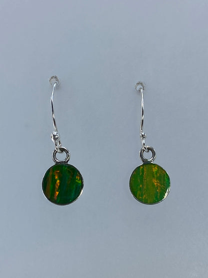 Aretes de ópalo de Fuego colgando, mostrando los destellos naturales de la piedra