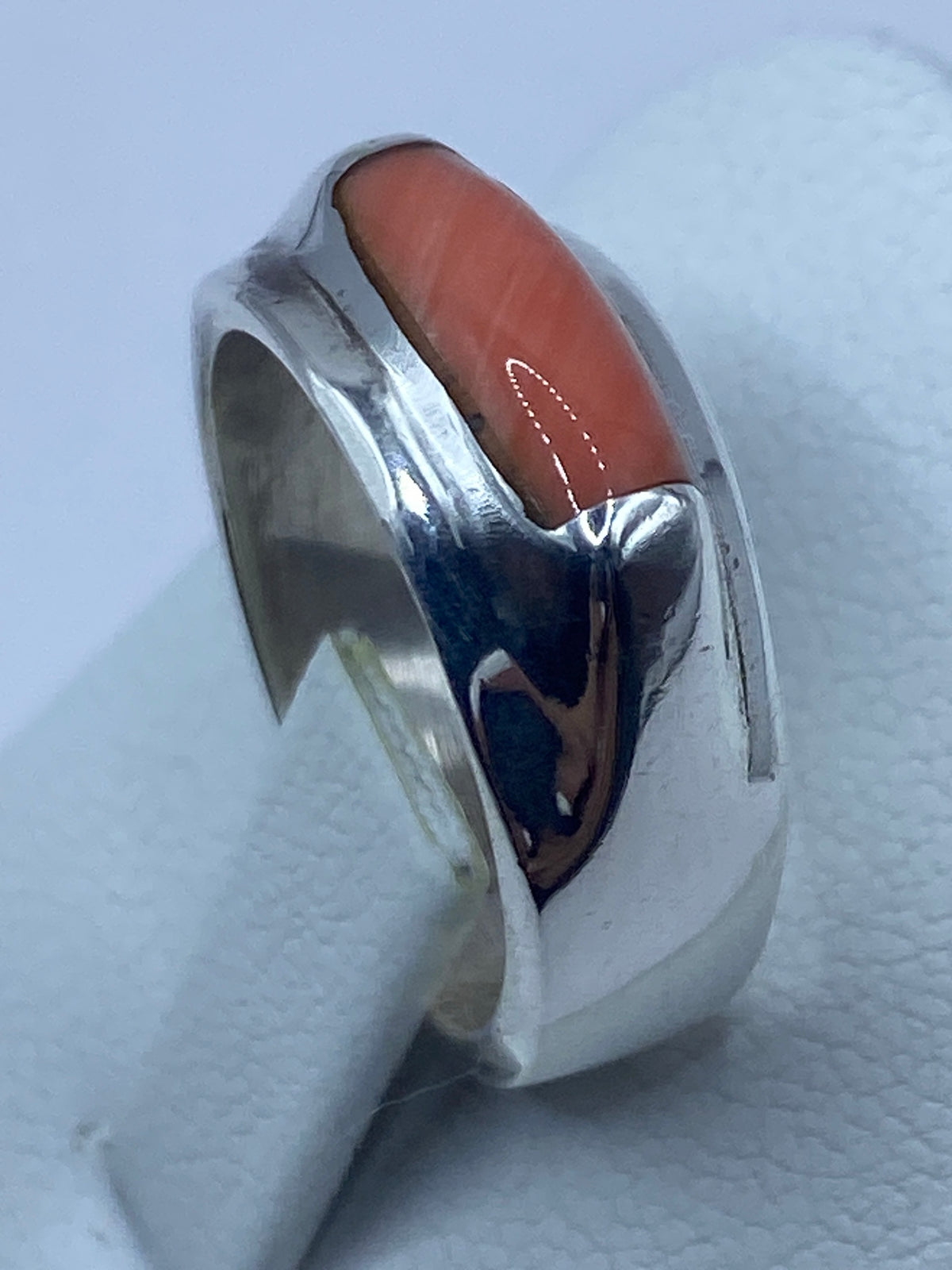Anillo con coral puesto en la mano, mostrando proporción y calidez de la piedra