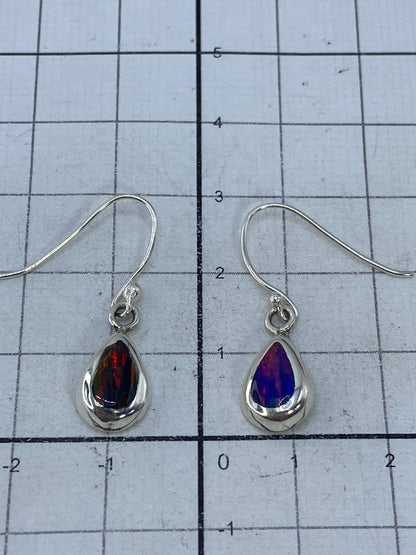 Aretes de ópalo de fuego sobre fondo blanco mostrando el sello 925