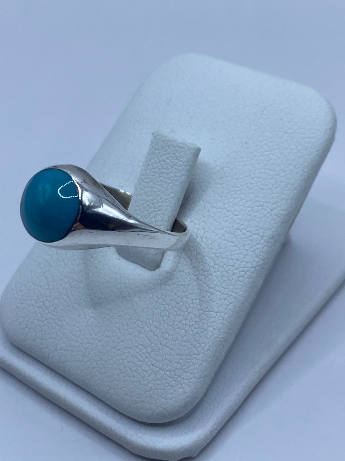 Anillo de turquesa en la mano mostrando el color azul cielo y el brillo de la piedra