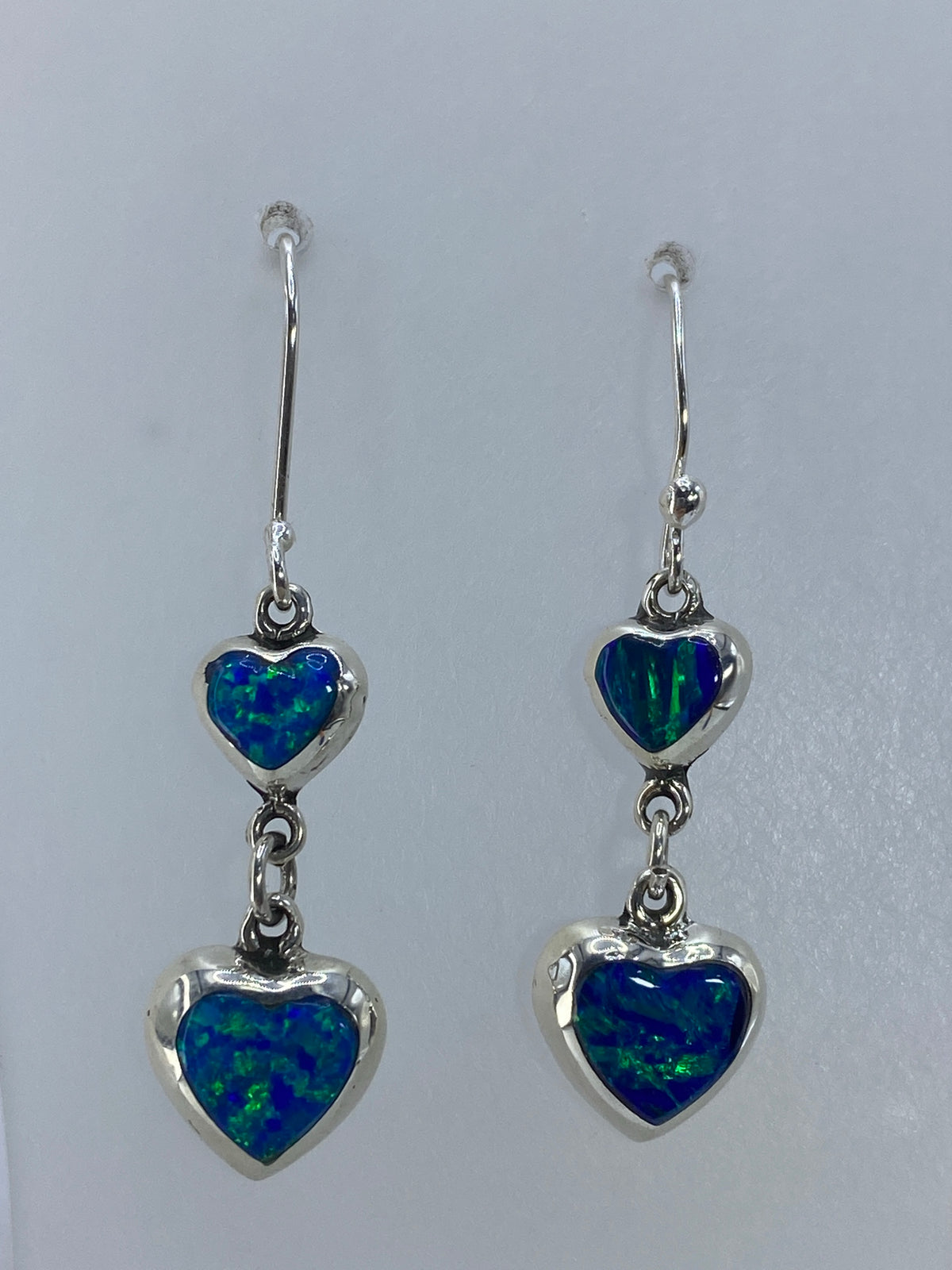 Detalle del ópalo de fuego verde olivo en su engaste de plata, mostrando los destellos cálidos
