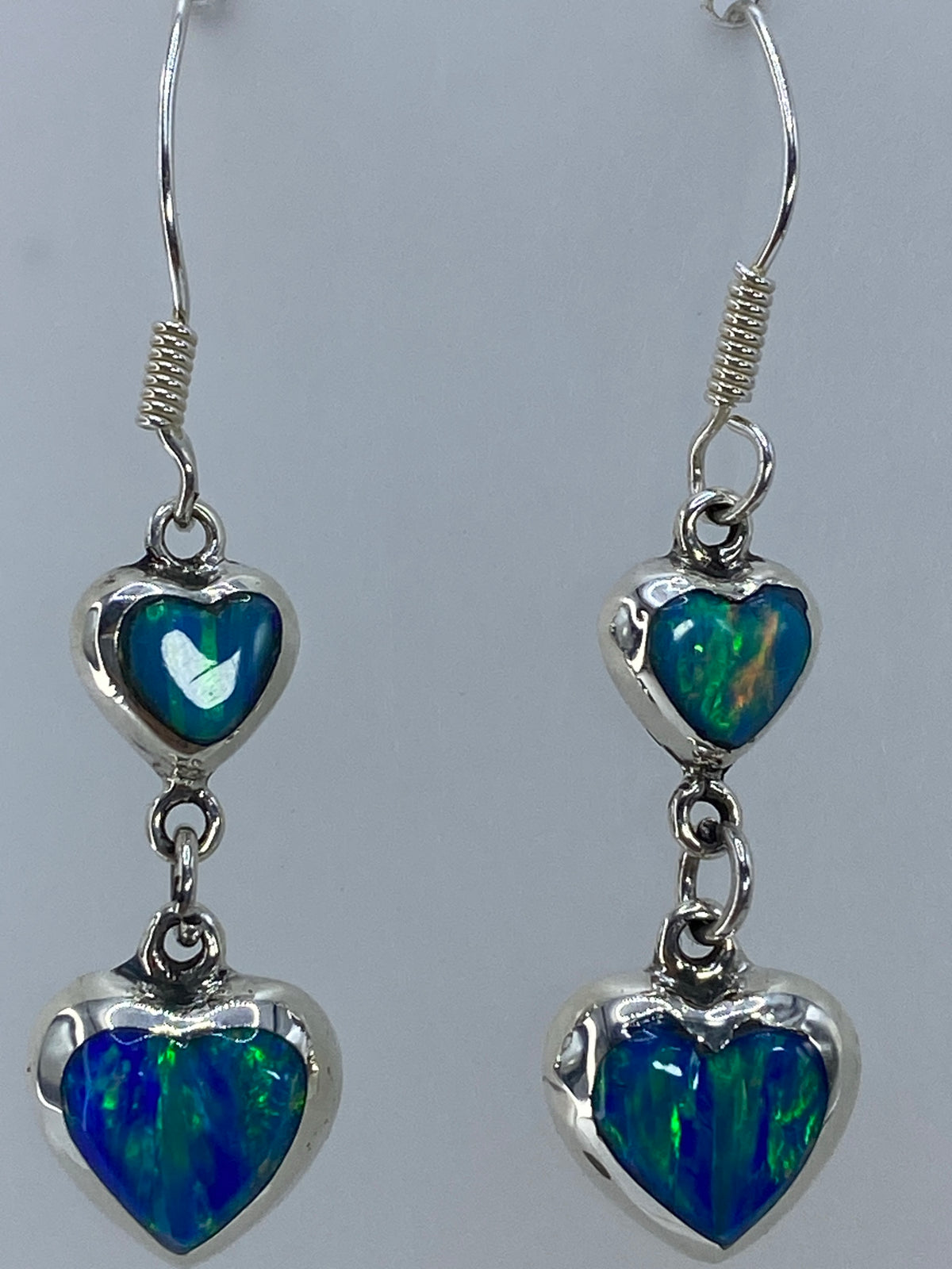 Aretes colgando con luz trasera, revelan el fuego amarillo y naranja en el verde