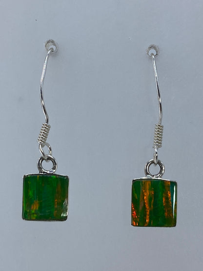 Par de aretes de plata 925 con ópalo de fuego naranja, colgando sobre fondo blanco