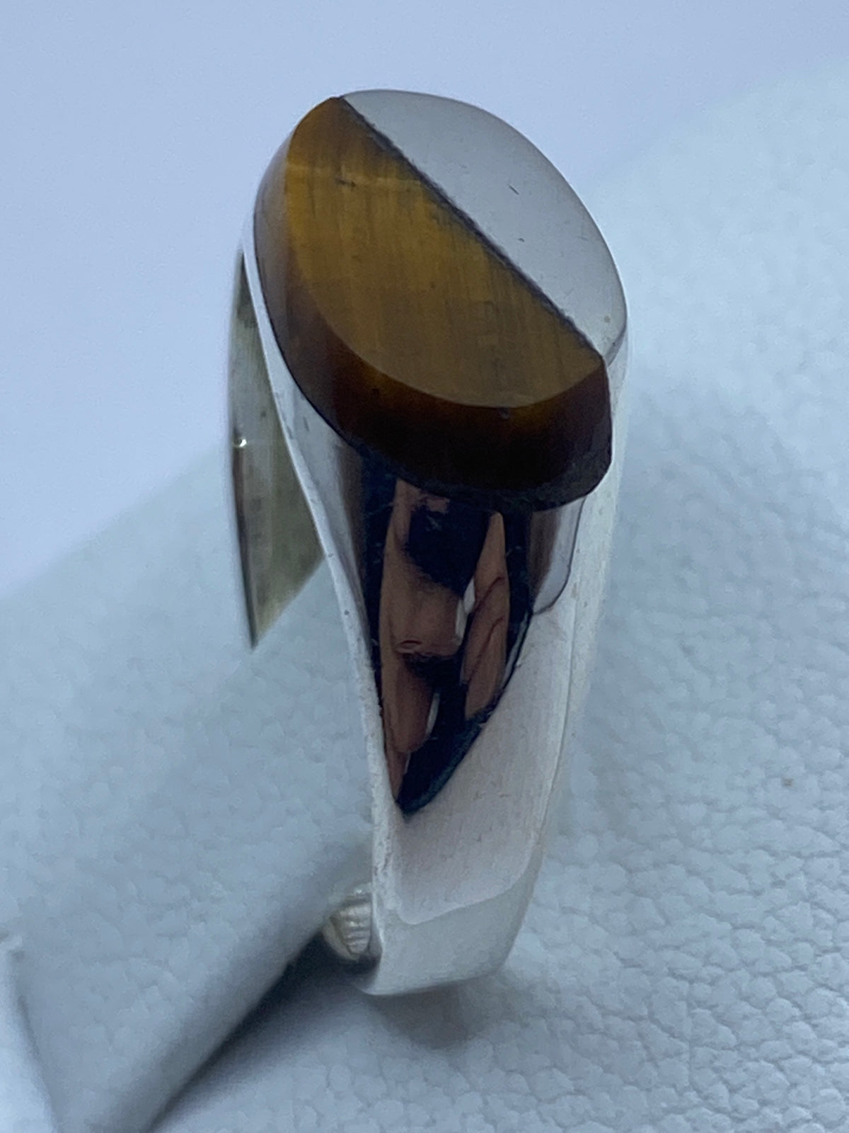 Detalle lateral del engaste de la piedra Ojo de Tigre en plata pulida
