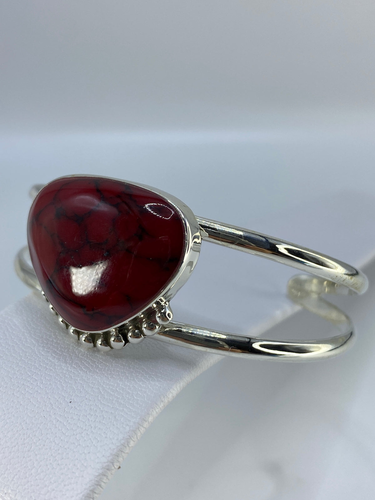 Brazalete de plata y coral puesto en la muñeca, mostrando el ancho de banda 6.2 cm