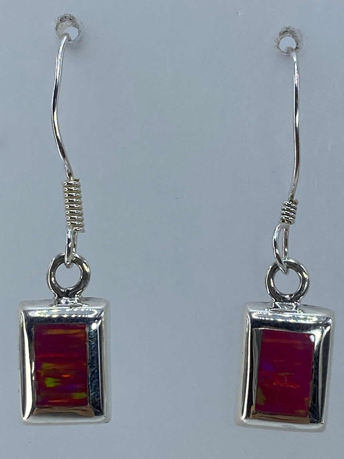 Par de aretes de plata sobre fondo neutro mostrando proporciones de 3 cm