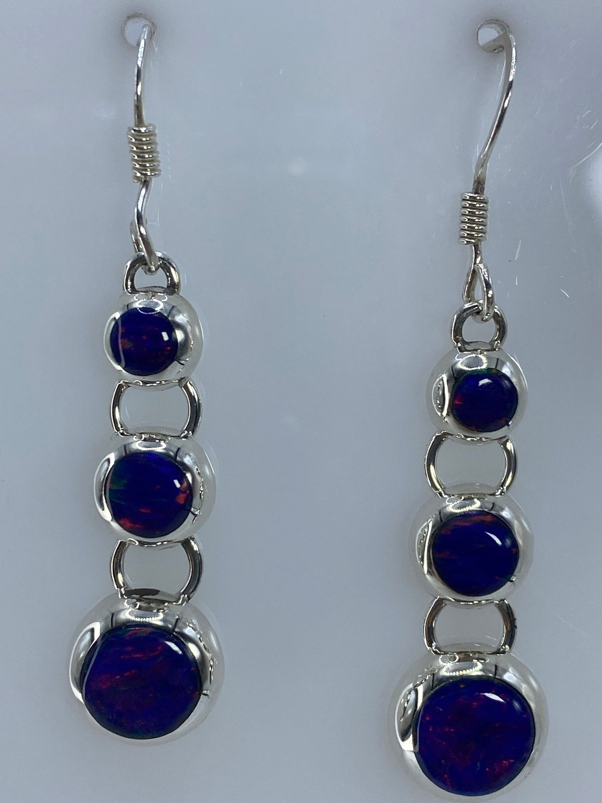 Aretes sobre regla de medición mostrando largo de 4.8 cm