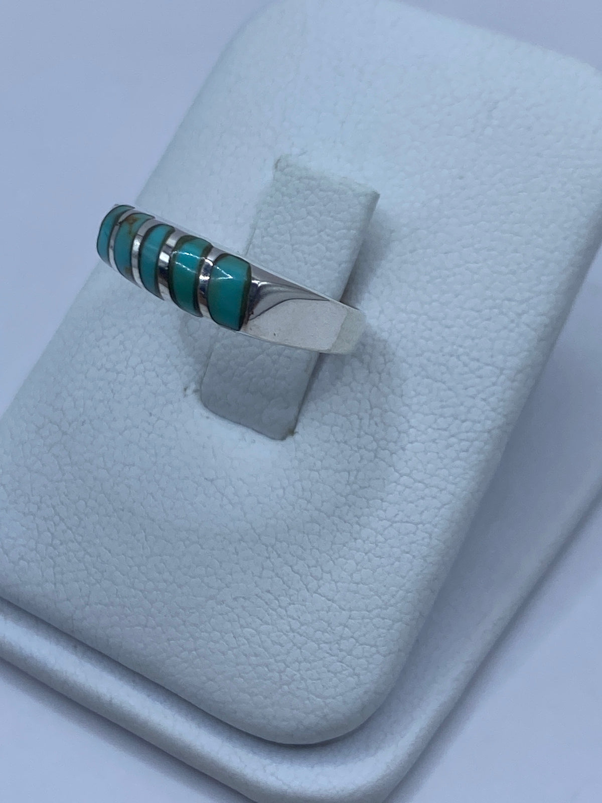 Vista lateral del anillo de plata con turquesa mostrando el engaste a mano