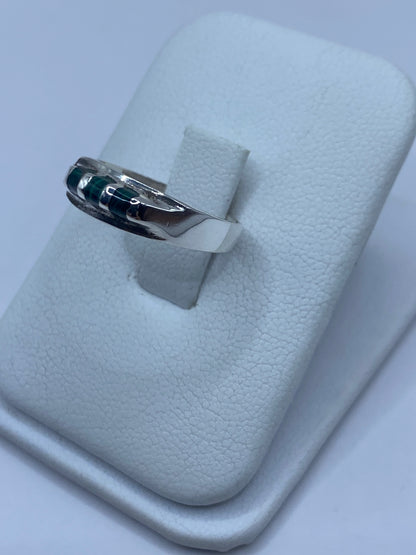 Anillo de plata con malaquita verde en la mano, mostrando el acabado pulido