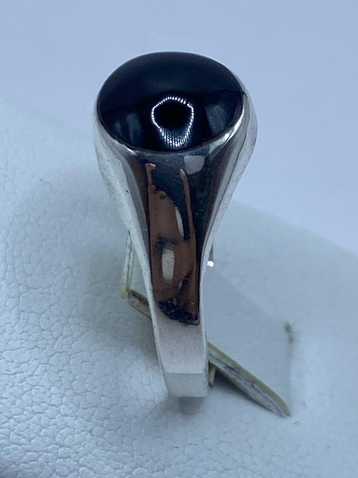 Anillo en la mano, mostrando cómo el ónix negro brilla contra la plata