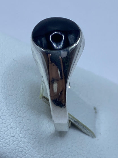 Anillo en la mano, mostrando cómo el ónix negro brilla contra la plata