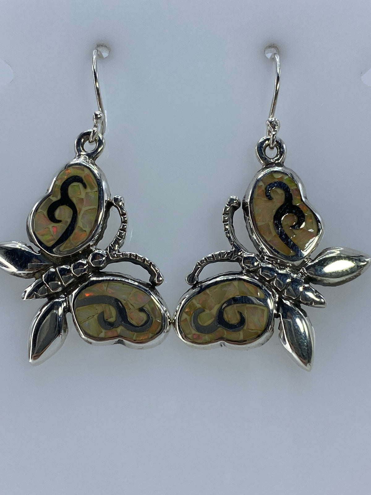 Detalle del ópalo de fuego en los aretes — colores naranja, rojo y verde