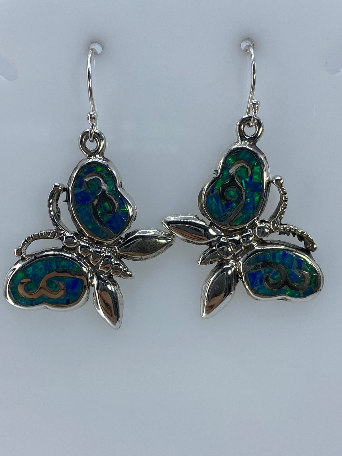 Detalle lateral de los aretes florales con incrustación de ópalo de fuego verde limón