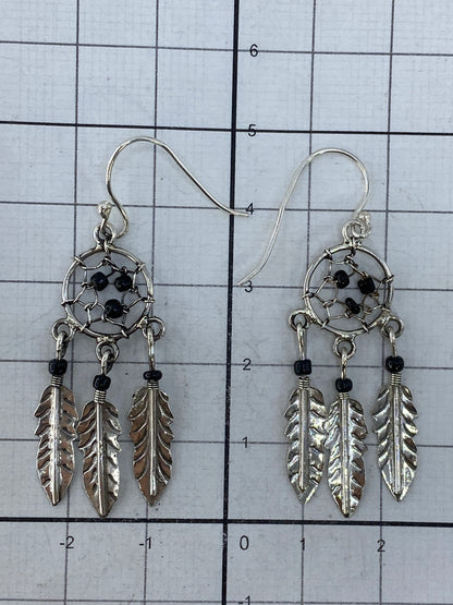 Aretes atrapasueños sobre fondo blanco mostrando el Quinto 925