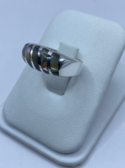 Detalle de los destellos verdes y azules de la concha de abulón en el anillo