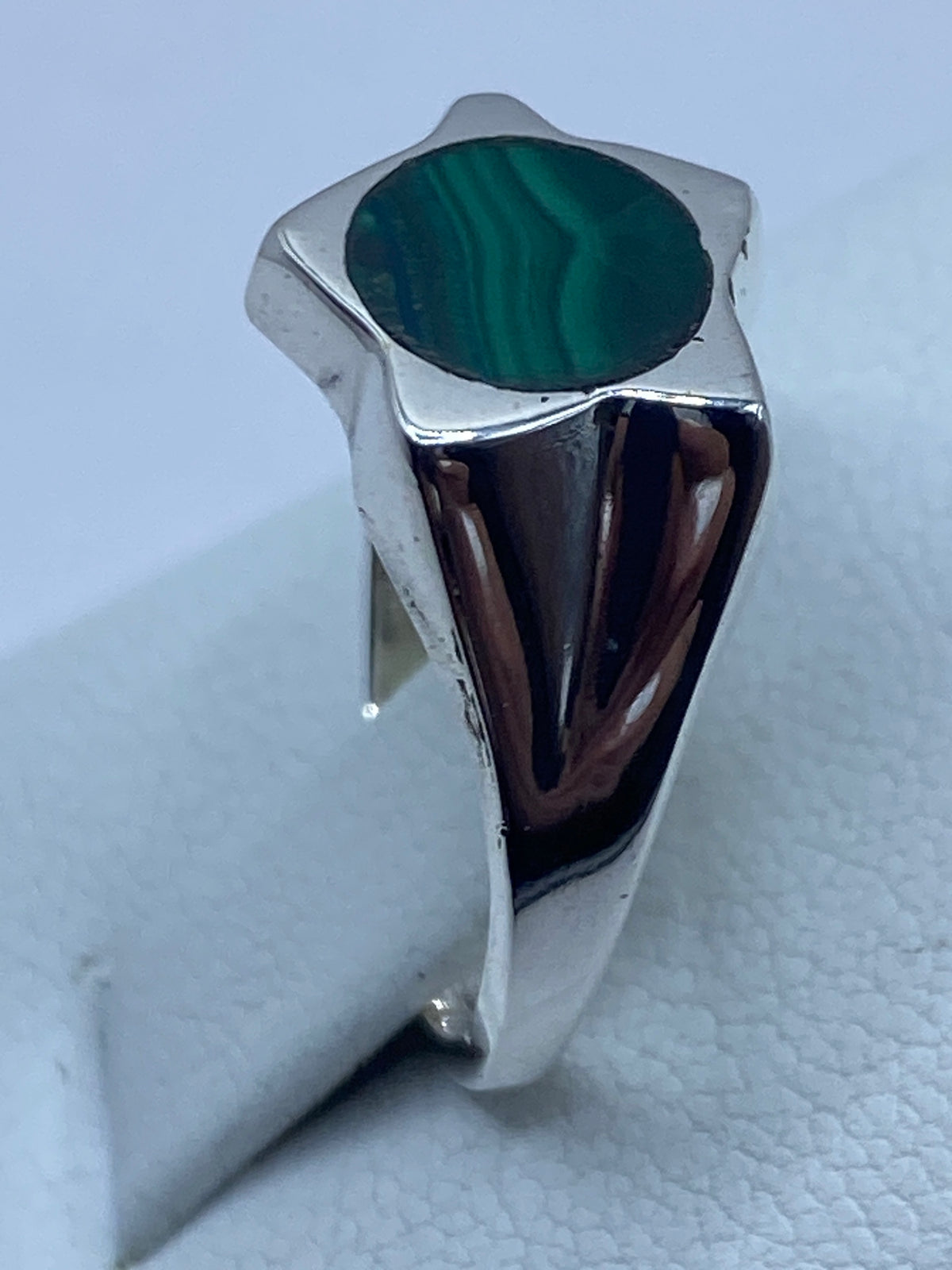 Anillo de malaquita y plata puesto en dedo, mostrando el verde profundo de la piedra