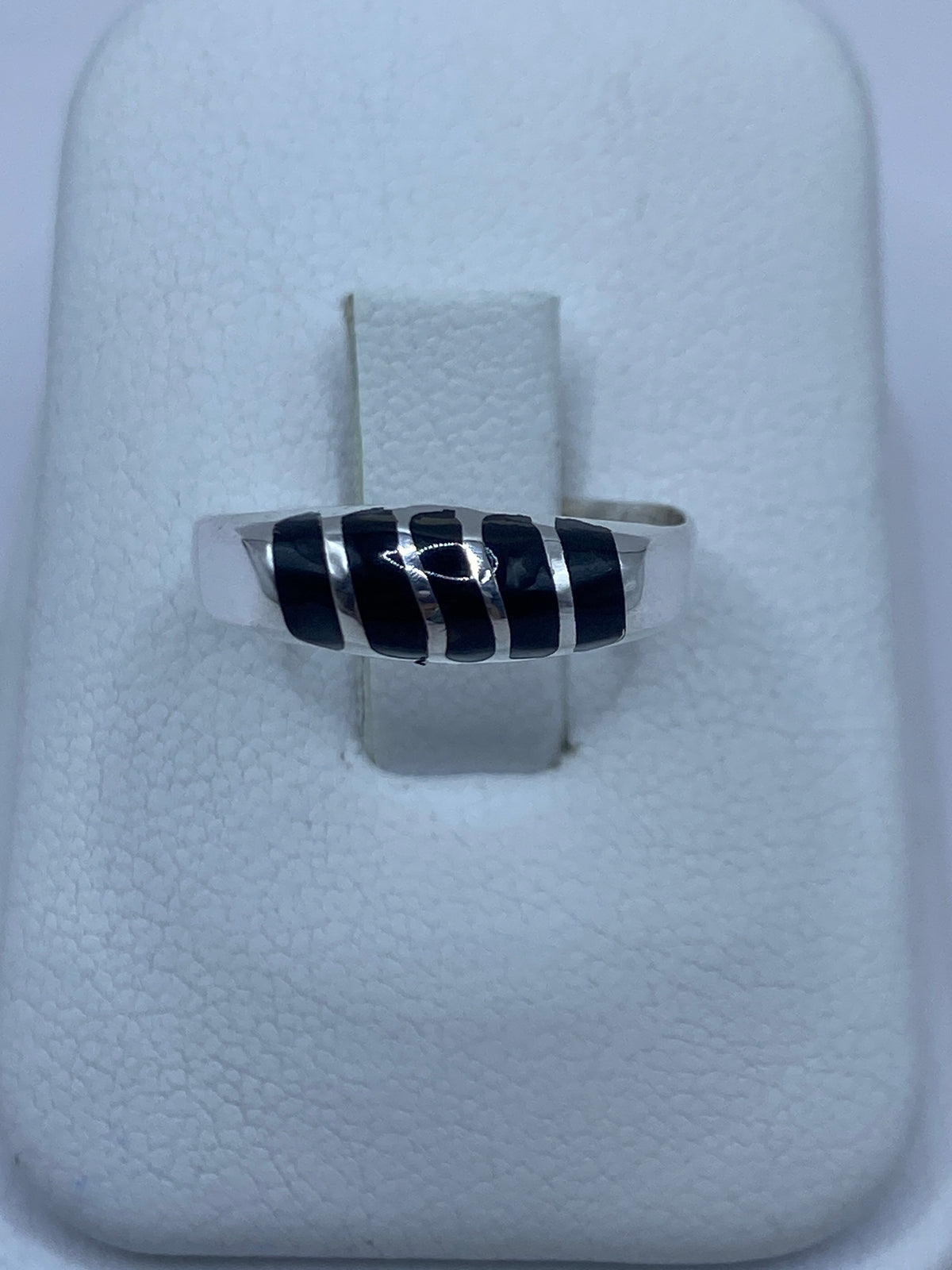 Anillo de plata con ónix negro en mano, mostrando el engaste minimalista