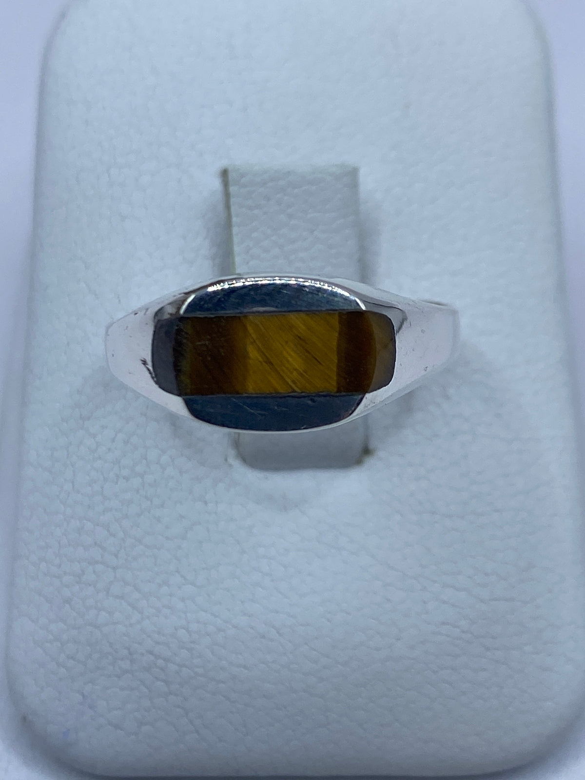 Anillo de plata 925 con Ojo de Tigre café en la mano de una persona