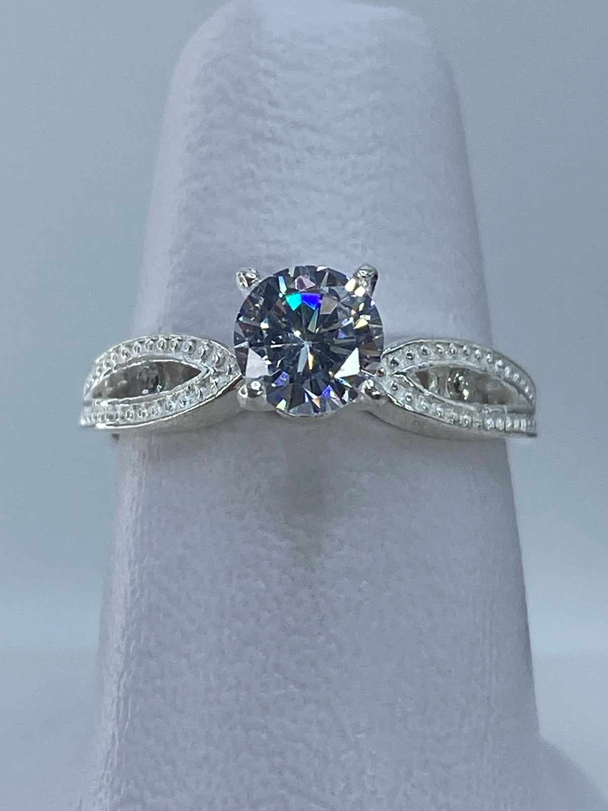 Anillo solitario de plata con circonia cristalina brillante en dedo de mujer
