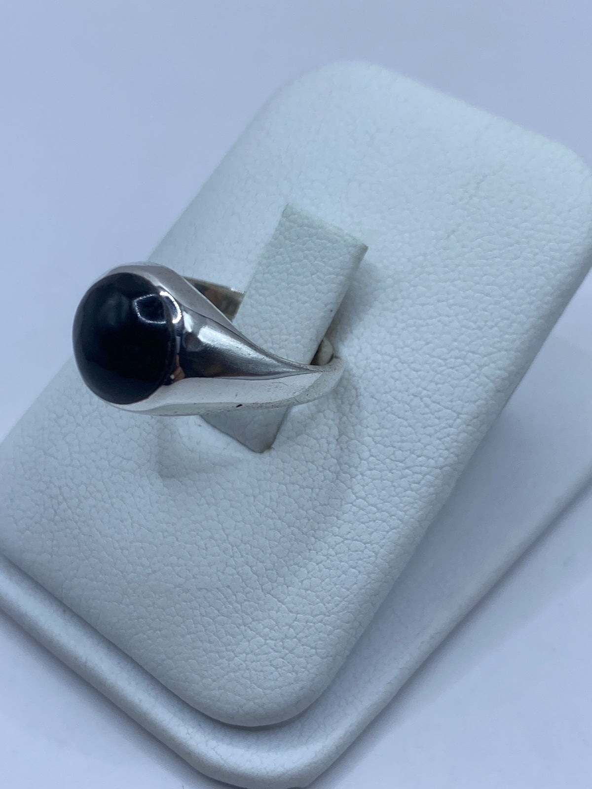 Anillo de ónix visto de frente mostrando el engaste a mano en plata