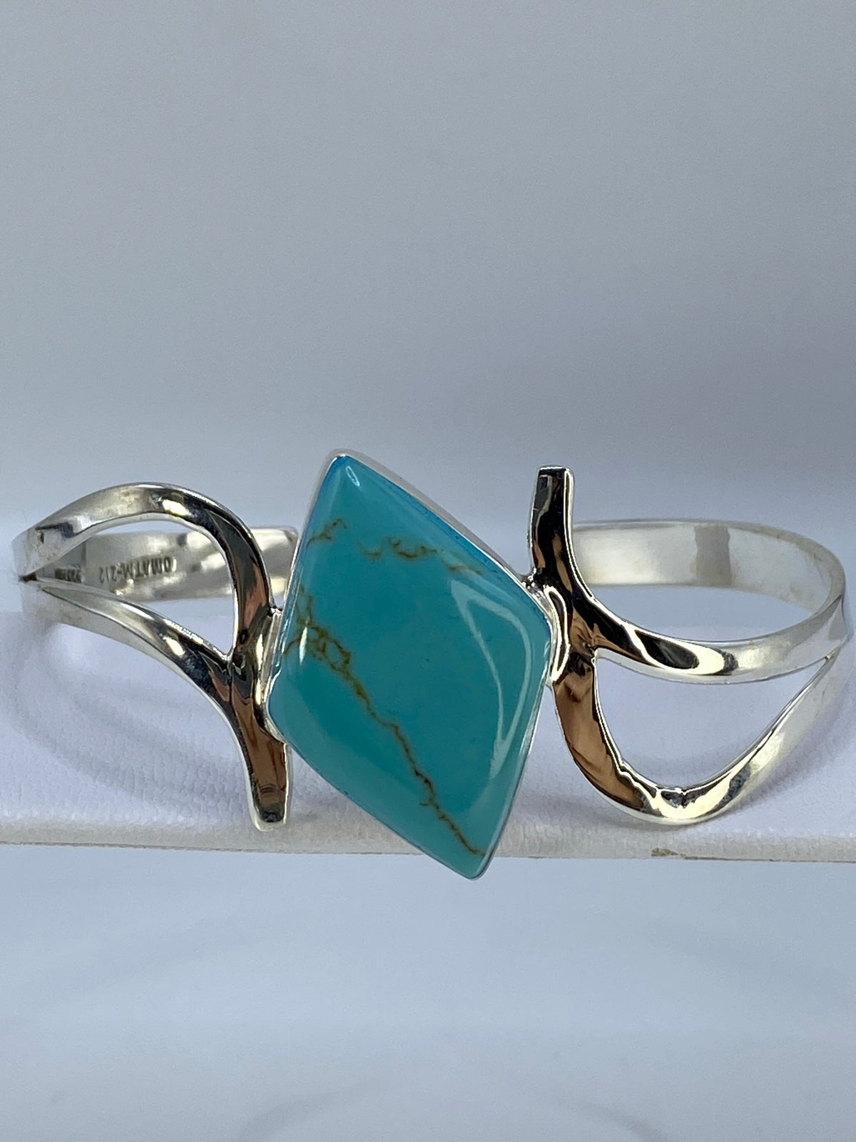 Vista lateral del brazalete con incrustación de turquesa y banda ancha de plata