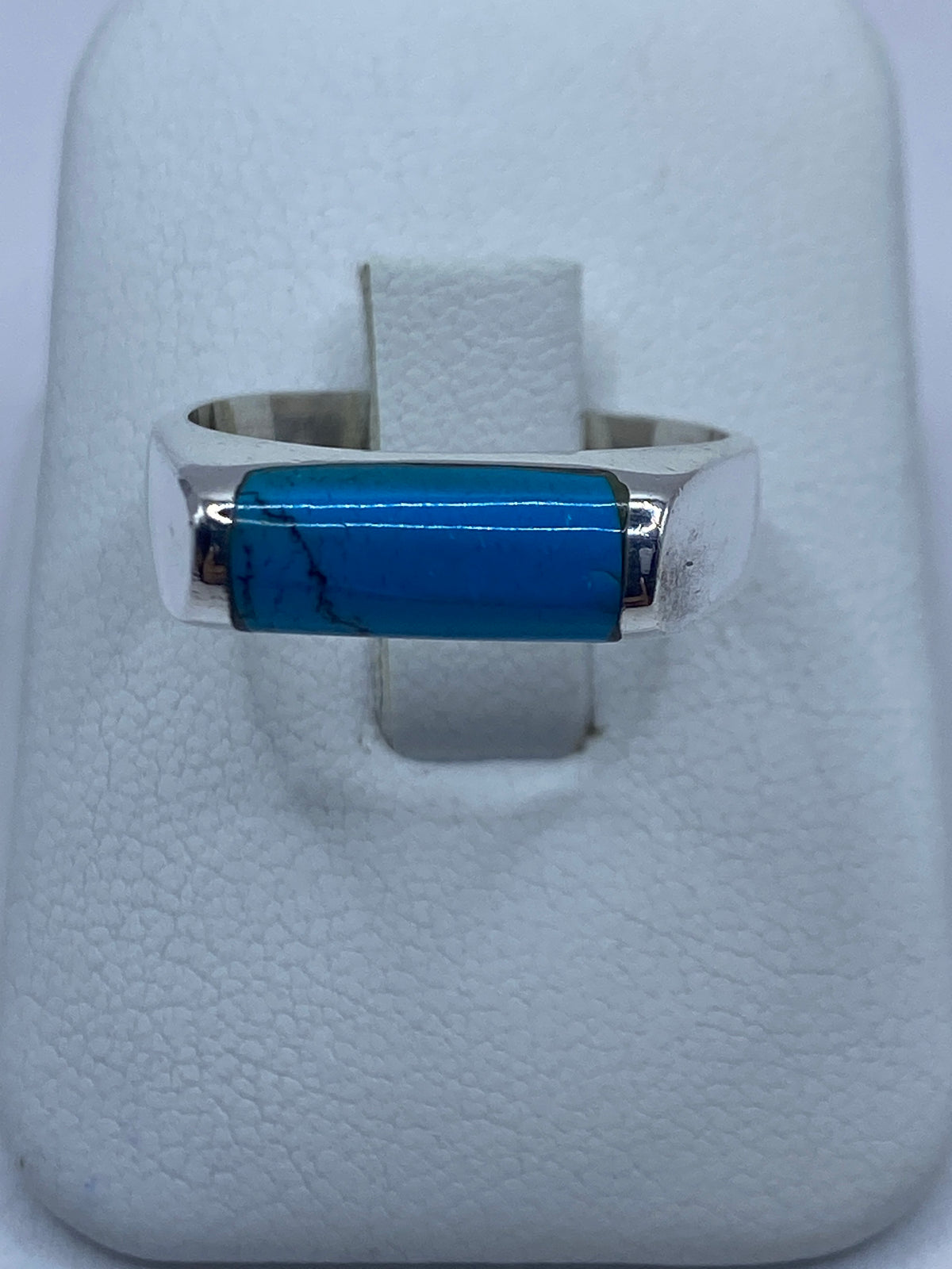 Anillo de plata 925 con turquesa azul cielo engastada, vista frontal sobre almohada blanca