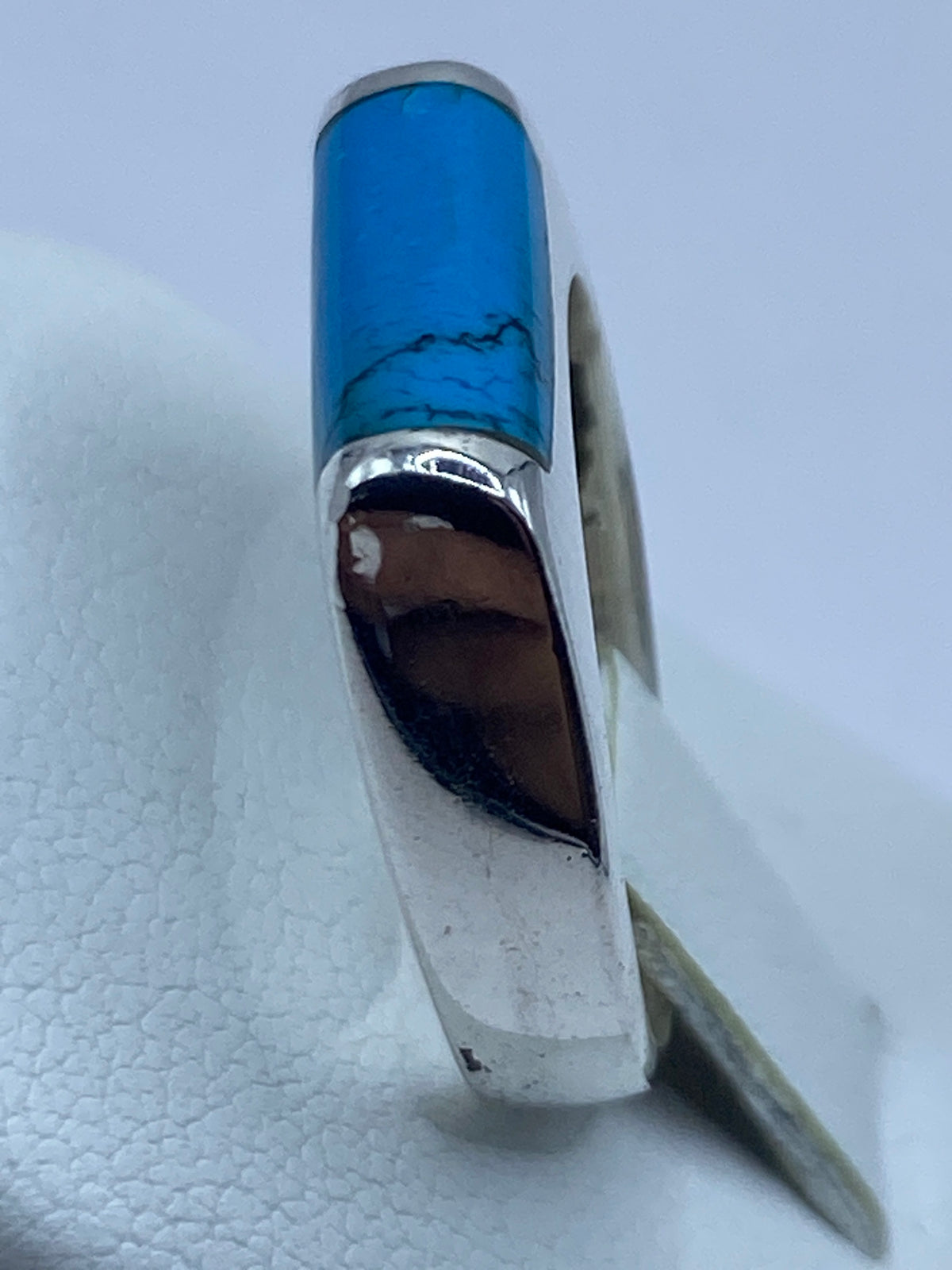 Anillo de turquesa en mano de una persona, mostrando el color azul cielo de la piedra