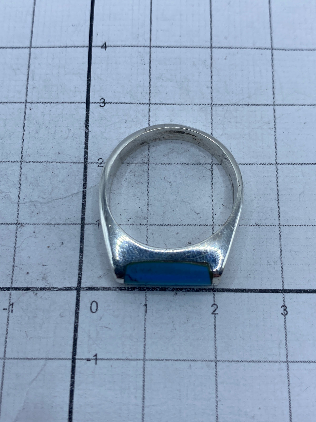 Anillo de plata con turquesa sobre regla de centímetros, mostrando la talla 9