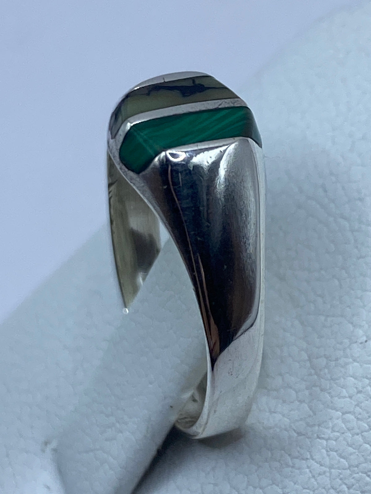 Vista lateral del anillo de plata con piedra verde malaquita