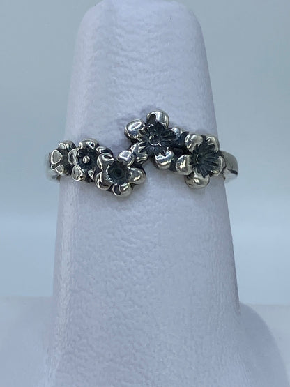 Anillo de plata 925 con flores en relieve repujado, visto desde arriba sobre fondo blanco