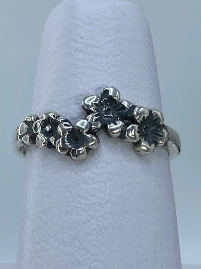 Anillo puesto en mano, visibles las tres flores repujadas