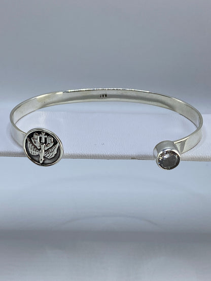 Brazalete de plata rígido con circonia cristalina, visto de frente en estuche