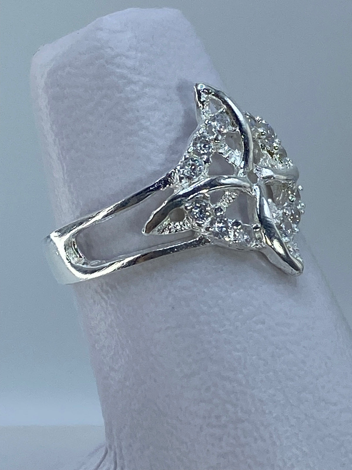 Vista frontal del anillo geometrico Nudo de Bruja mostrando el brillo de la micro-circonia