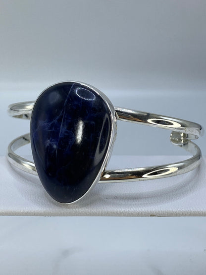 Brazalete abierto en plata con piedra lapislázuli, mostrando la amplitud de la banda de 4.3 cm