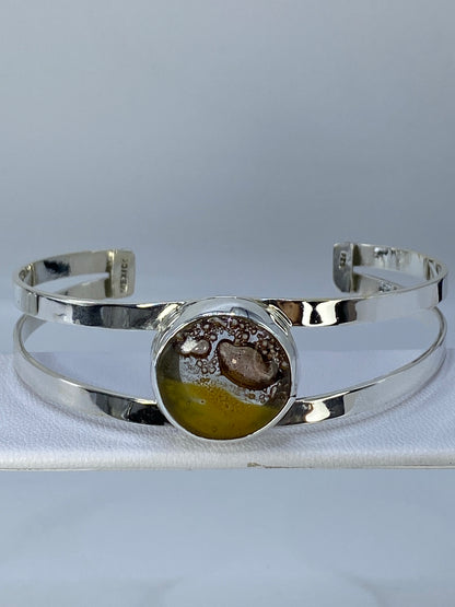 Brazalete rígido de plata 925 sobre fondo gris, vista frontal mostrando diámetro y ancho