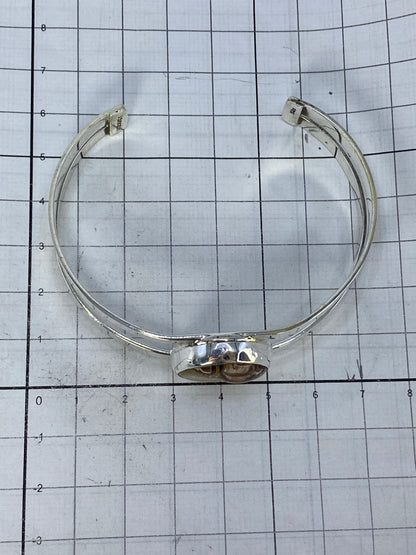 Brazalete sobre escala de centímetros mostrando medidas precisas: 6.1 cm diámetro interior