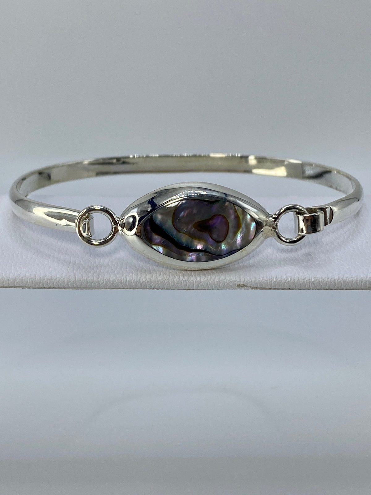 Brazalete de plata rígido tipo esclava con piedra multicolor engastada en el centro