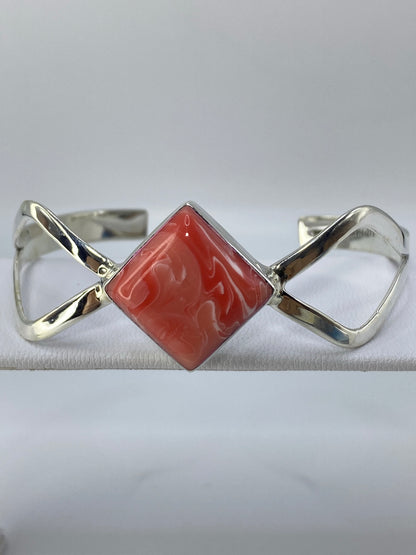 Detalle del engaste de coral rosa en plata, mostrando la precisión del trabajo a mano