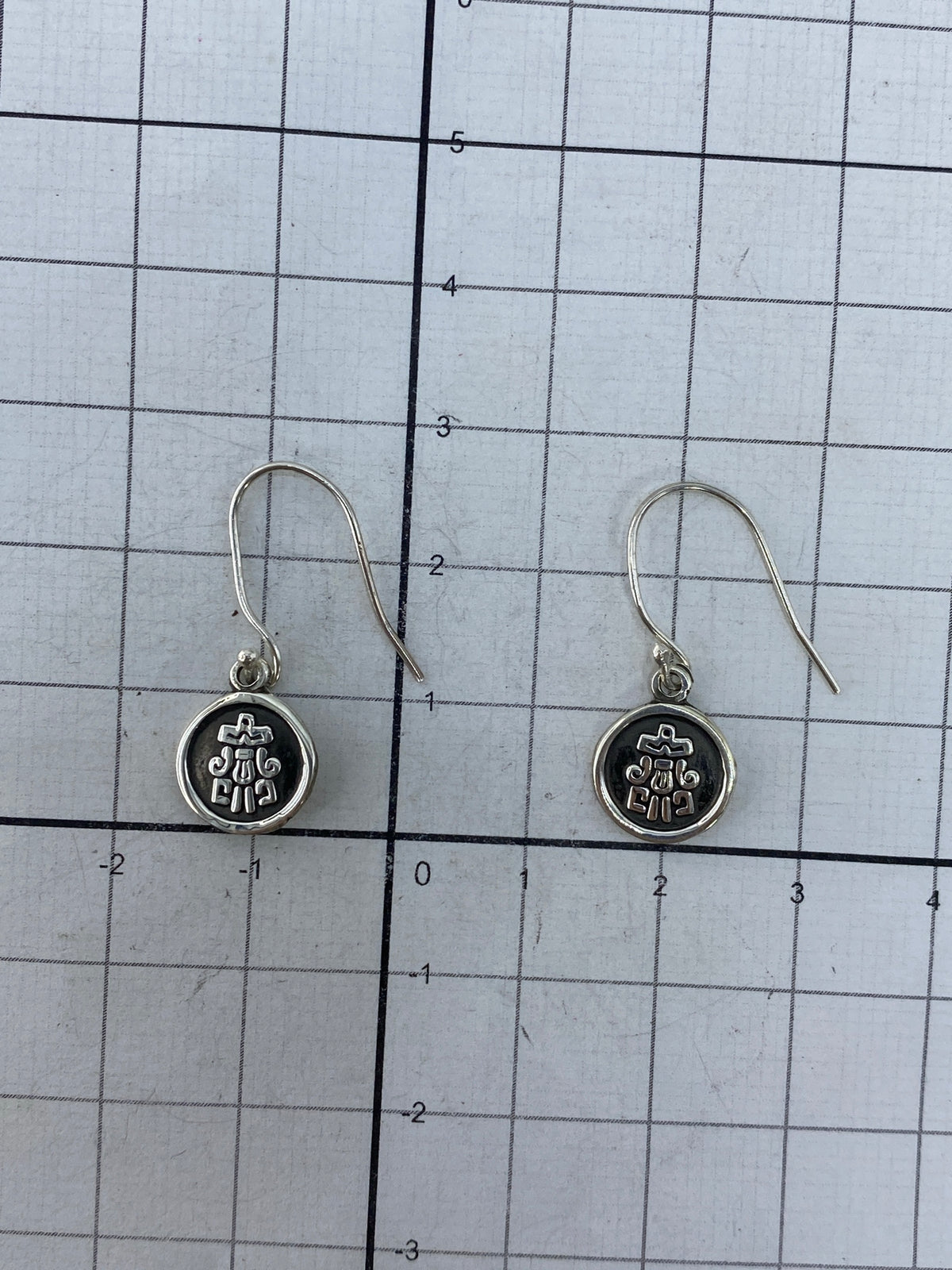 Reverso de los aretes mostrando el trabajo del repujado desde atrás y el Quinto 925