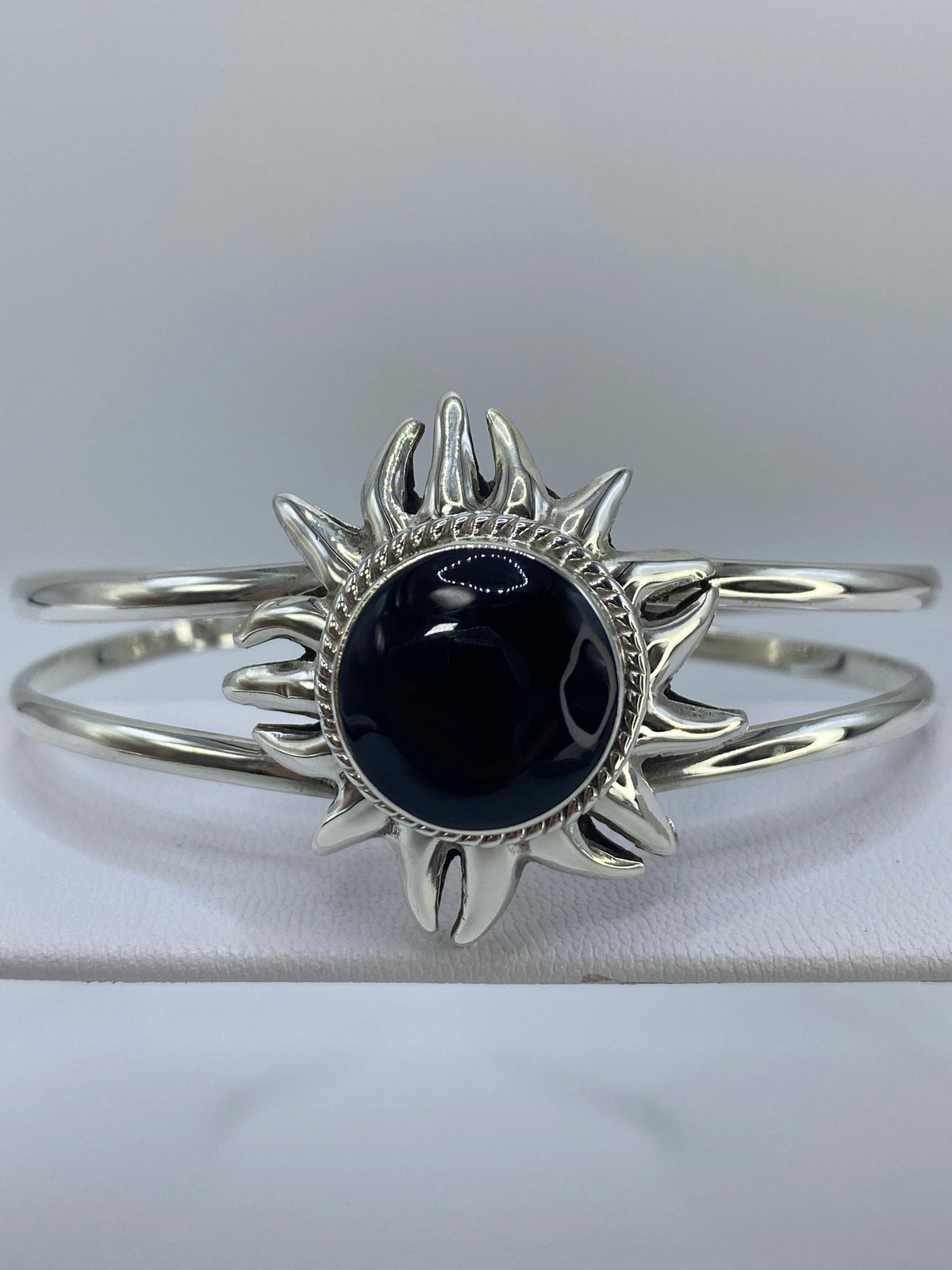 Brazalete cerrado en la muñeca mostrando el Quinto 925 y el ónix negro pulido